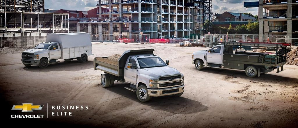 Chevrolet medium-duty commercial trucks at a construction site, highlighting fleet capability, heavy-duty performance, and reliable truck maintenance for business and job-site operations.