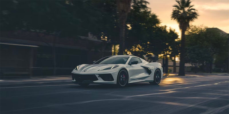 White Chevrolet Corvette Stingray parked on the street while the sun is setting
