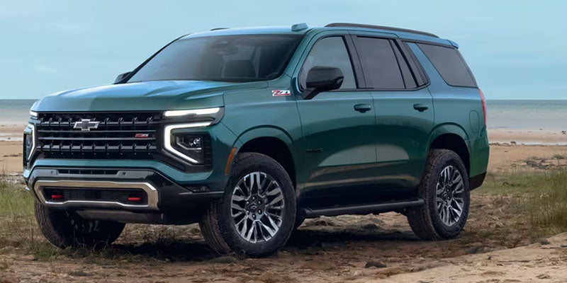 Chevrolet Suburban parked on the beach next the ocean on a warm day