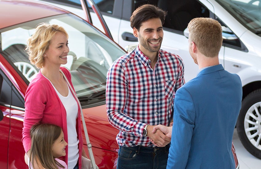 Customers shaking hands with the sales manager after buying a car from Criswell Chevrolet of Gaithersburg