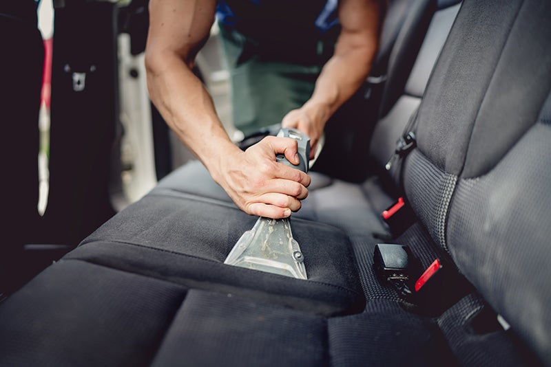 Owner using a vacuum to keep his vehicle clean and polished