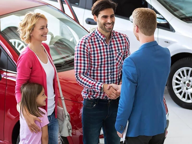 Customer shaking hands with sales manager after buying a used car